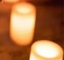 A row of lit candles glowing in a dark room, from Alchemy’s Candlelit Yoga Melt poster.