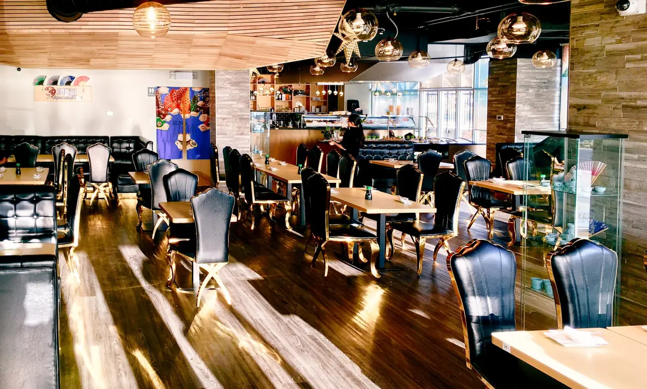 JUKAI's dining room, with a warm wood ceiling, pendant lights and the sushi counter.