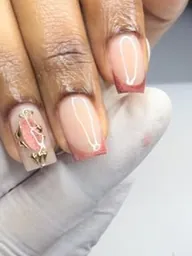 Ongles nude aux pointes rose cuivré, un ongle orné d’un bijou doré.