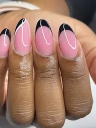 Ongles en amande rose aux pointes noires, sur un gainage d’ongles naturels.