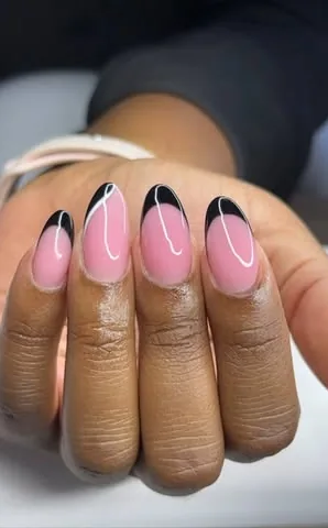 Ongles en amande rose aux pointes noires traversées d’une fine ligne blanche.